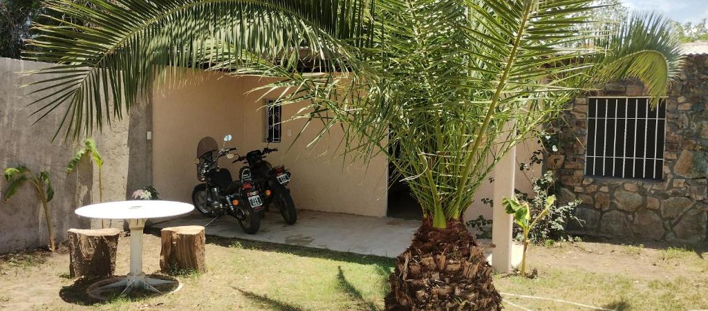 Una motocicleta estacionada al lado de una casa con una palmera en Hospedaje Don Juan en San Javier