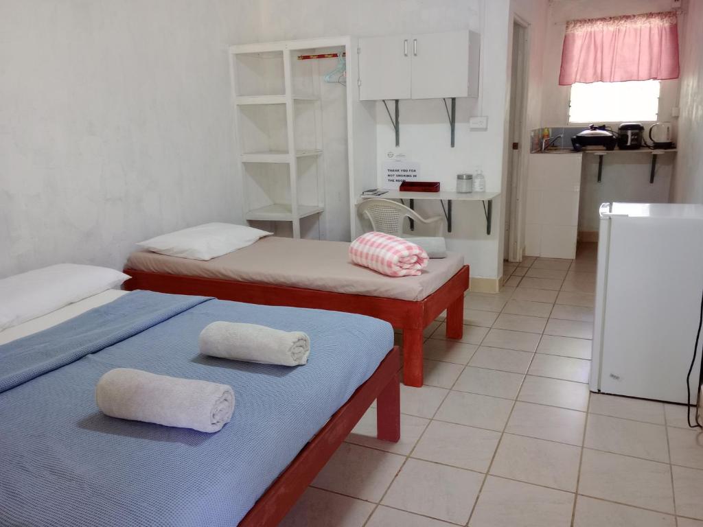 a kitchen with two beds and a refrigerator at Kathy B Guesthouse in Luganville