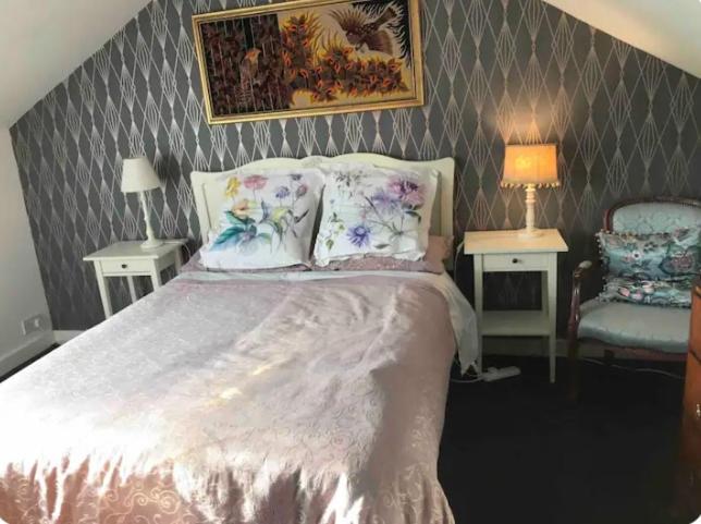 a bedroom with a bed with two tables and two lamps at Room with a view in Winchester