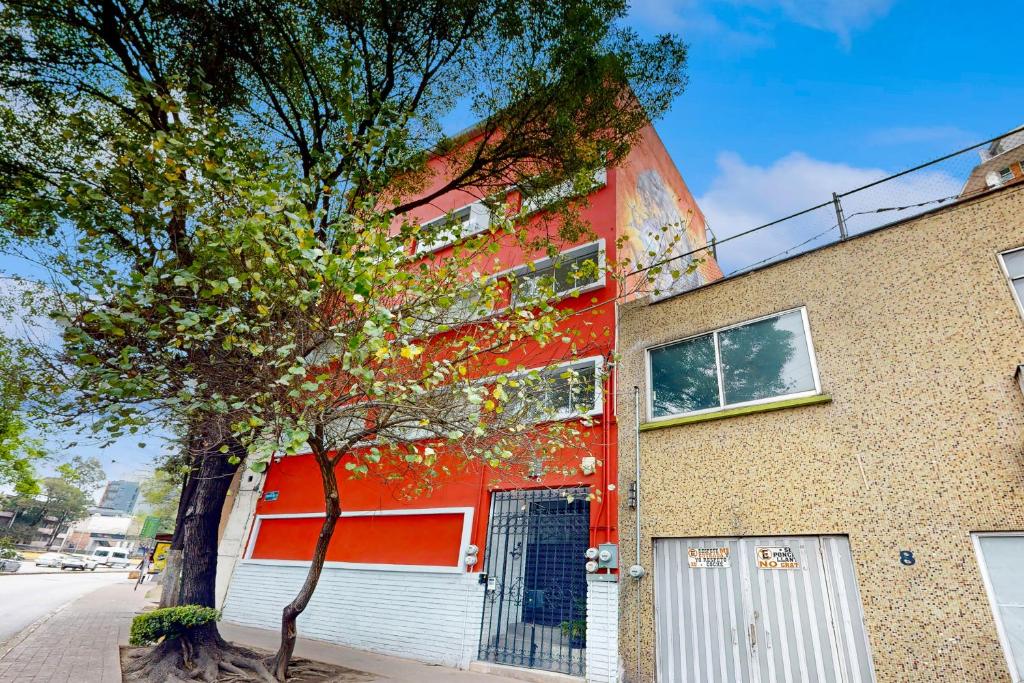a red building with a tree in front of it at Cadetes 47 #203 in Mexico City