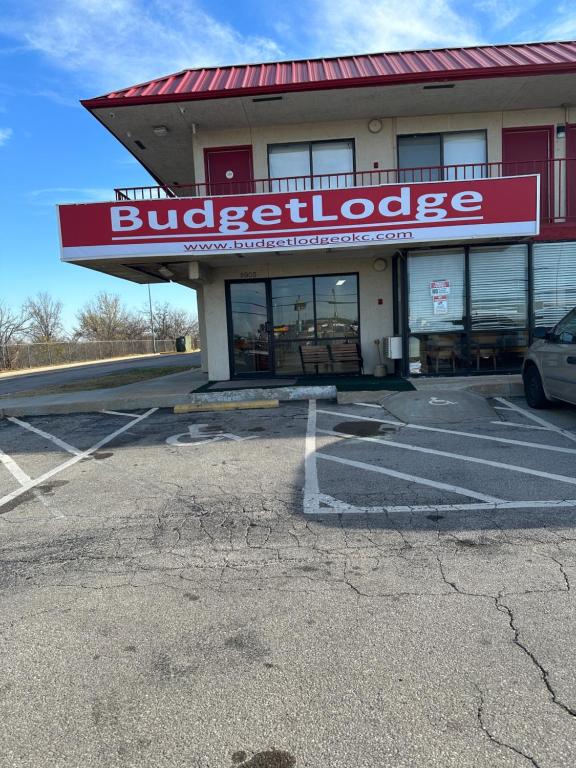 un edificio con un cartel de intolerancia a las hamburguesas en un estacionamiento en Budgetlodge, en Oklahoma City