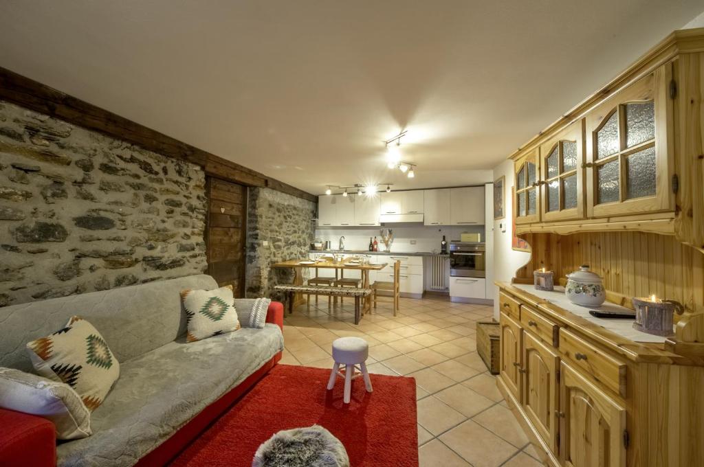 a living room with a couch and a kitchen at Maison Chasseur Alpine Design Lodge in Champoluc