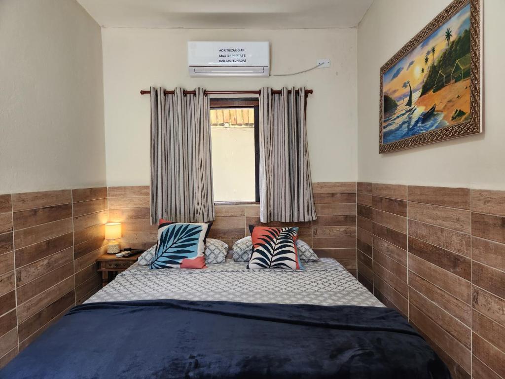 烏巴圖巴的住宿－Pousada Morena Raiz，卧室配有带枕头的床铺和窗户。