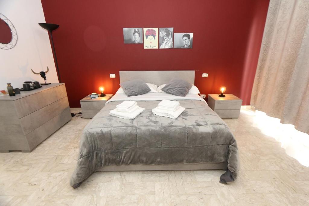 a bedroom with a large bed with red walls at Bed and Breakfast Donna Maria in Bari