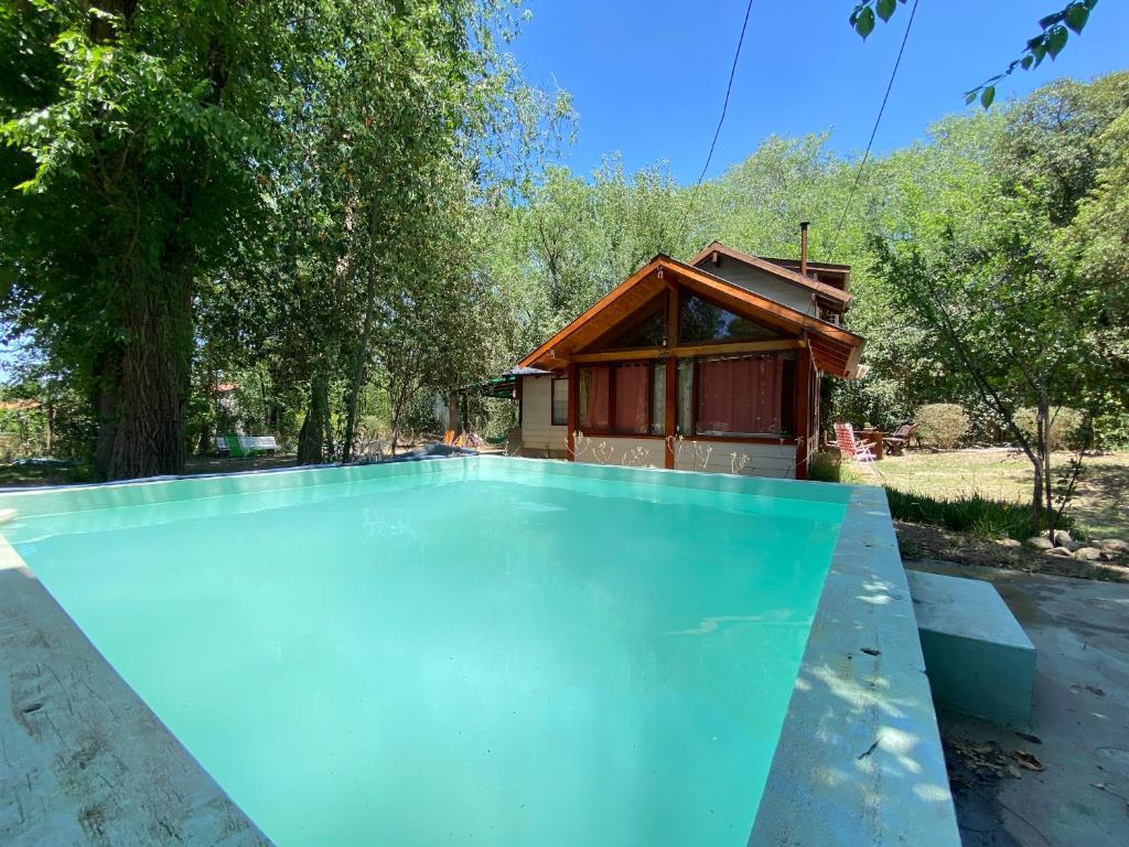 een zwembad met een huis op de achtergrond bij Complejo Jardín de Olmos in Villa Giardino