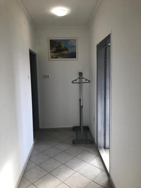 um quarto com um quarto branco com um espelho e uma moldura na parede em Apartman DALT em Trebinje