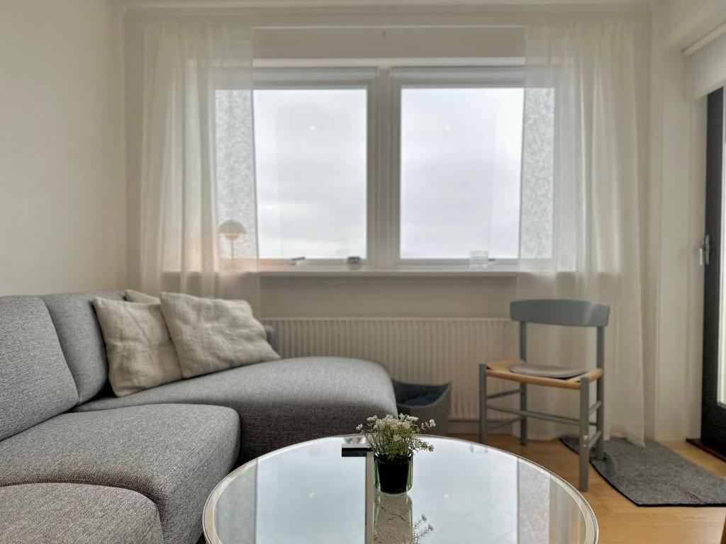 een woonkamer met een bank en een glazen tafel bij Apartment in Torshavn in Tórshavn