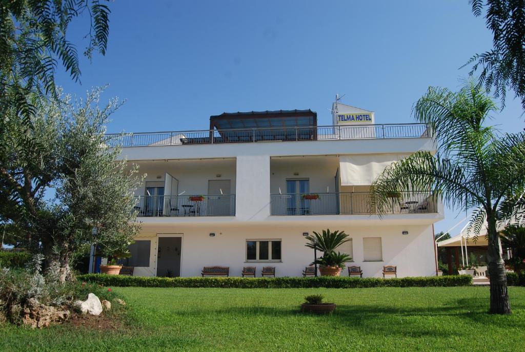 a white building with a train on top of it at Telma Hotel in Terracina