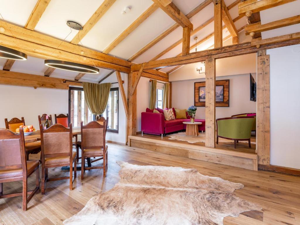 a dining room and living room with wooden beams at Biber Art Apartment 1 in Biberwier