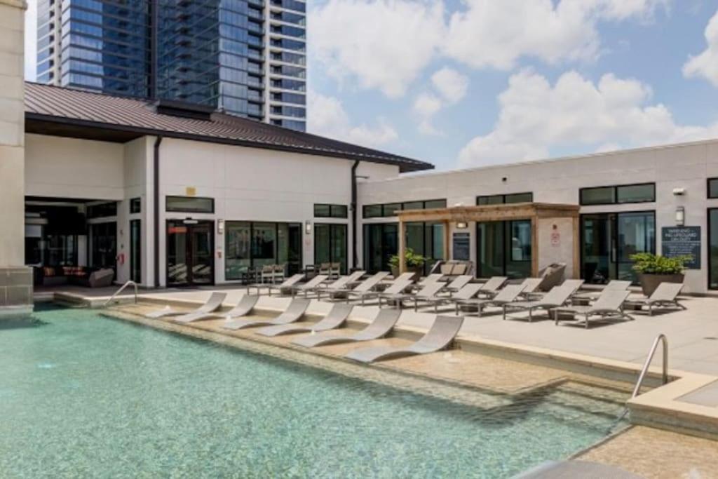 a pool with lounge chairs and a building at The Bentler #2 in Houston