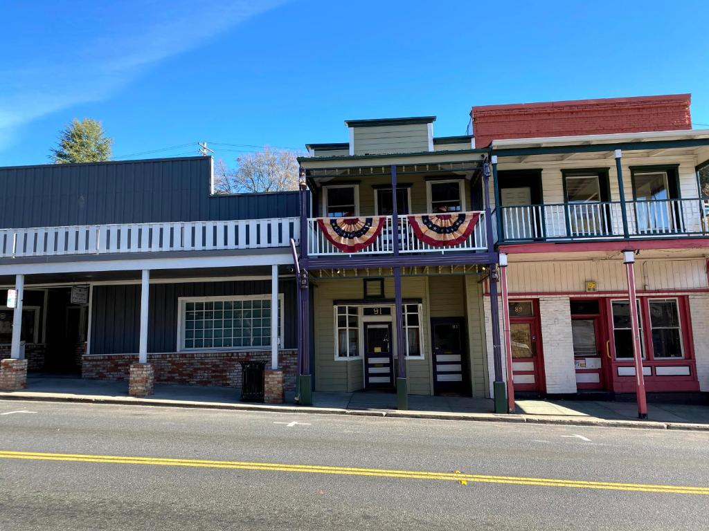 a row of buildings on a street with american flags at Historic Washington St Balcony in Sonora