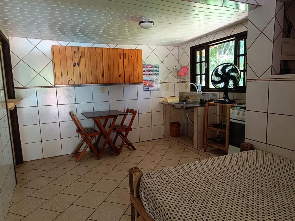 a kitchen with a table and chairs in a room at Hotel Jussara Cultural - Joinville in Joinville