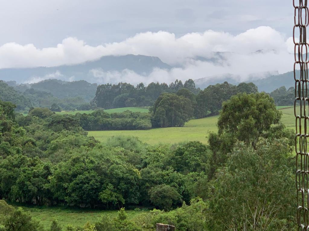 Rio Rufino的住宿－Pousada Vale do Tigre，享有郁郁葱葱的绿色田野和树木的景致。
