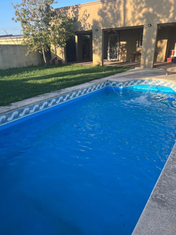 einen Pool mit blauem Wasser vor einem Haus in der Unterkunft Las Emes in Suipacha