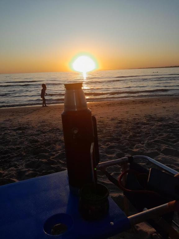 een fles op een surfplank op het strand bij zonsondergang bij Apartamento en Atlantida in Atlántida