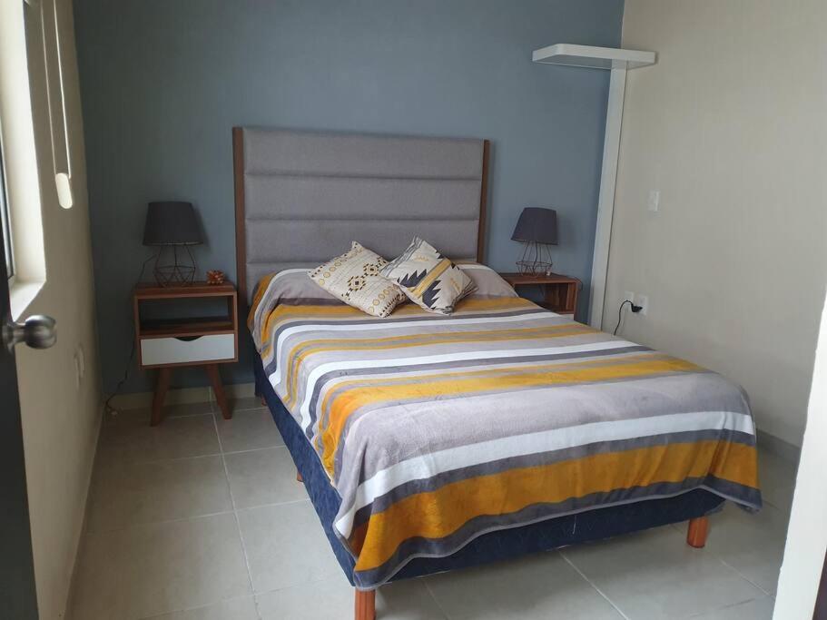 1 dormitorio con 1 cama con 2 mesas y 2 lámparas en Casa llena de vida y buena vibra con las amenidades necesarias para que pases una estancia de 10!, en Colima