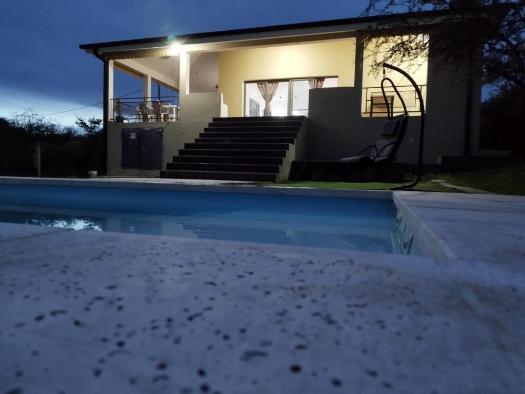 a house with a swimming pool in front of it at Estancia Borke - Carlos Paz in Estancia Vieja