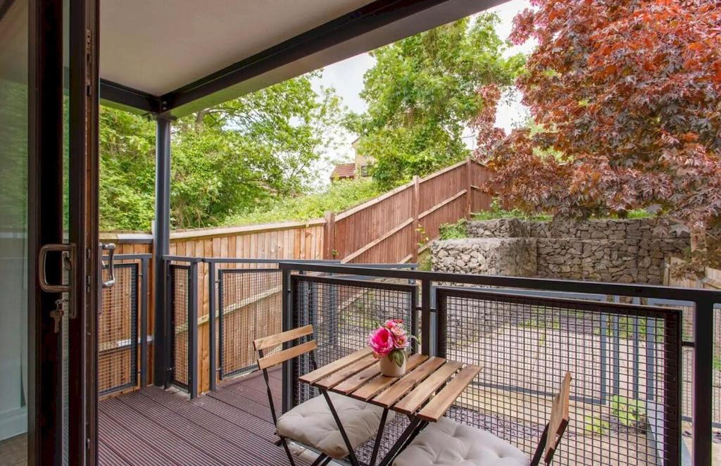 eine Terrasse mit einem Tisch und Stühlen auf dem Balkon in der Unterkunft Manor House Studios By Morethanstays in London