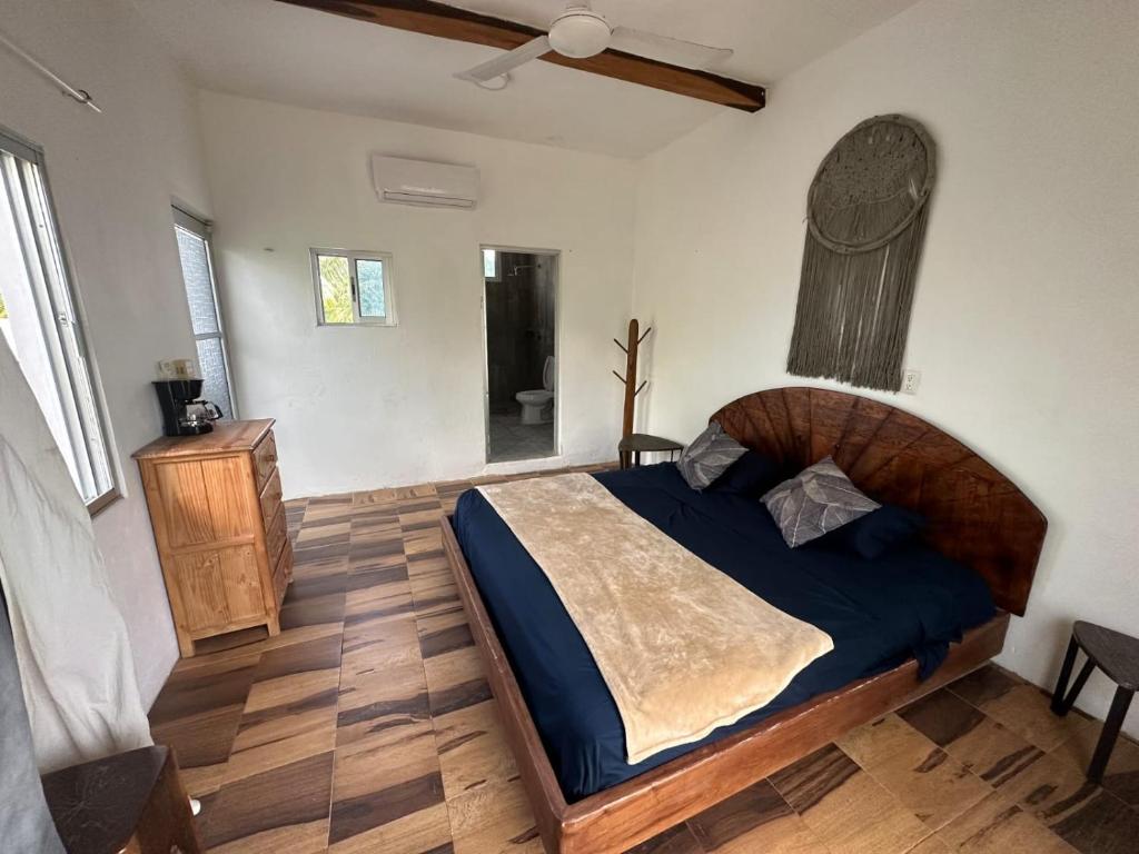 um quarto com uma cama grande e piso em madeira em Haciendita Xul-Ha em Xul-Ha
