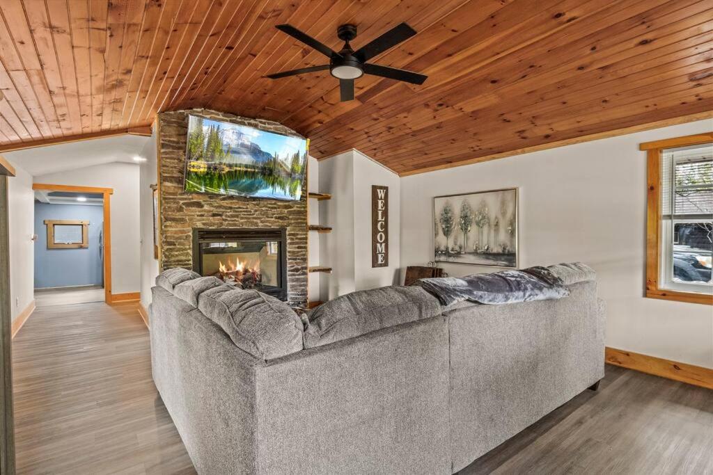 salon z kanapą i kominkiem w obiekcie Cozy Home W/ King Bed & Lake access w mieście Canandaigua