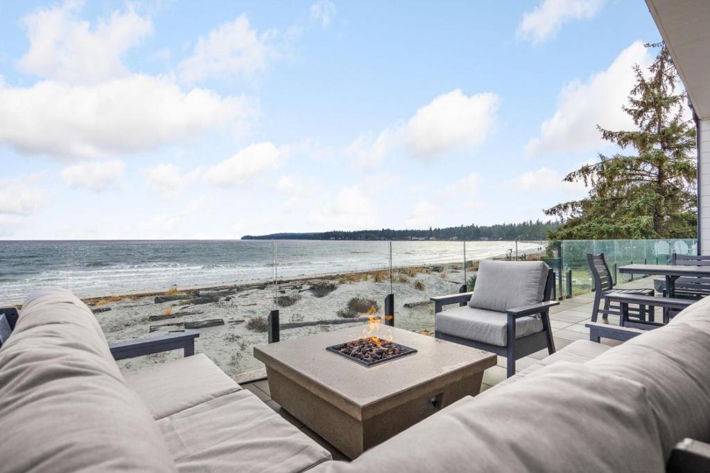 uma sala de estar com um sofá e uma fogueira na praia em Beachfront Luxury Suite #19 at THE BEACH HOUSE em Campbell River