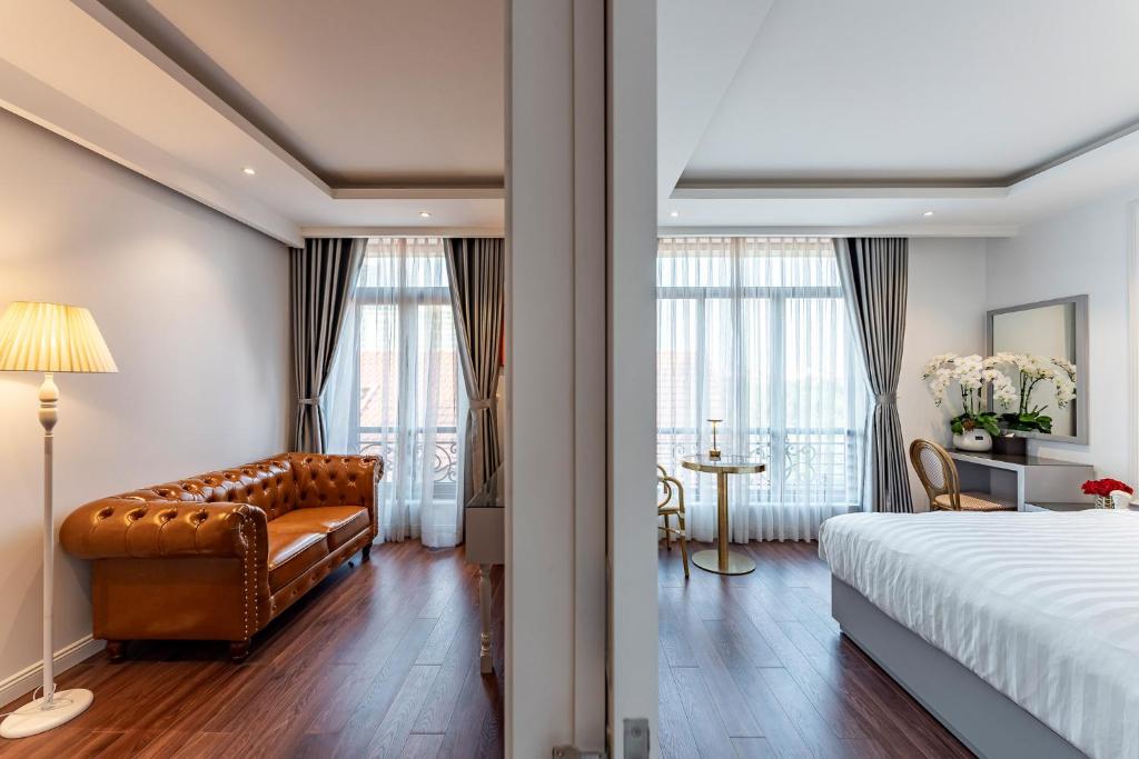 une chambre d'hôtel avec un lit et un canapé dans l'établissement Golden Star Apartment & Hotel, à Hô-Chi-Minh-Ville