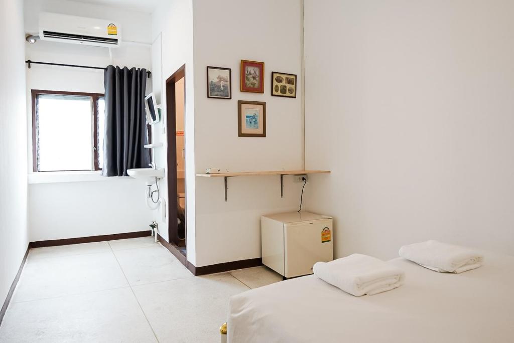 Dieses weiße Zimmer verfügt über 2 Betten und ein Fenster. in der Unterkunft GO INN Asiatique The Riverfront - Charoen Krung โกอินน์ เอเซียทีค เจริญกรุง in Godown