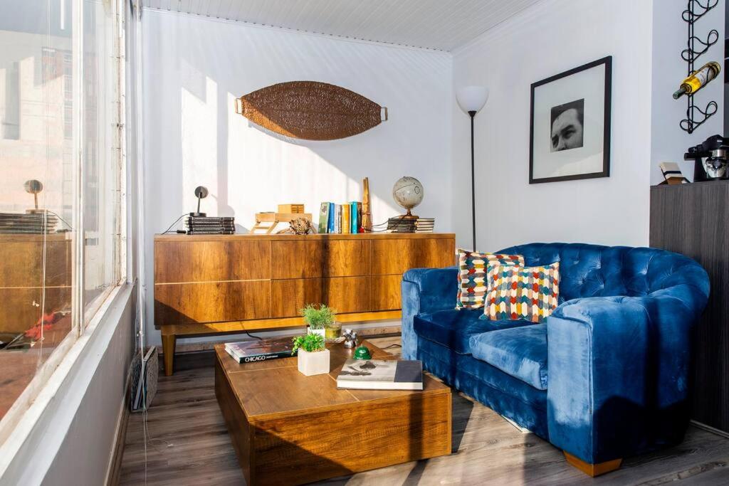 a living room with a blue couch and a table at - Atardecer en Capri - Duplex Remodelado in Bogotá