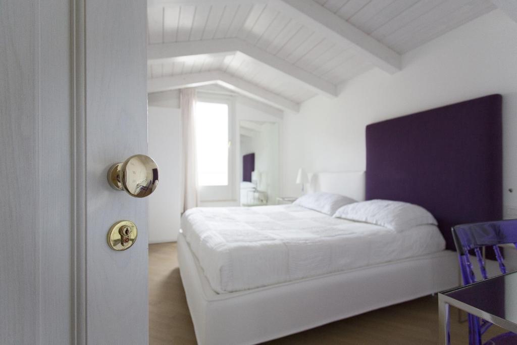 Un dormitorio blanco con una cama blanca y una ventana en Residenza dei Suoni, en Matera