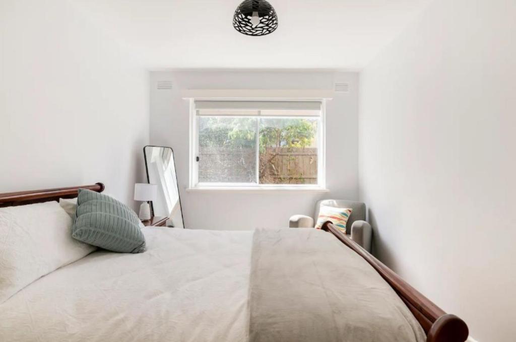 une chambre blanche avec un lit et une fenêtre dans l'établissement Unwind in style only 7km from CBD, à Melbourne