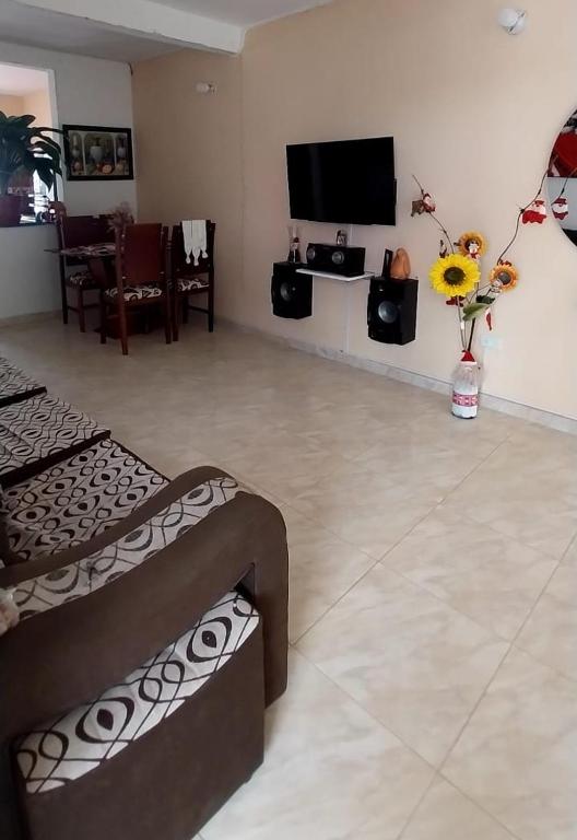 a living room with two beds and a flat screen tv at acogedora casa Rochi in Guaduas