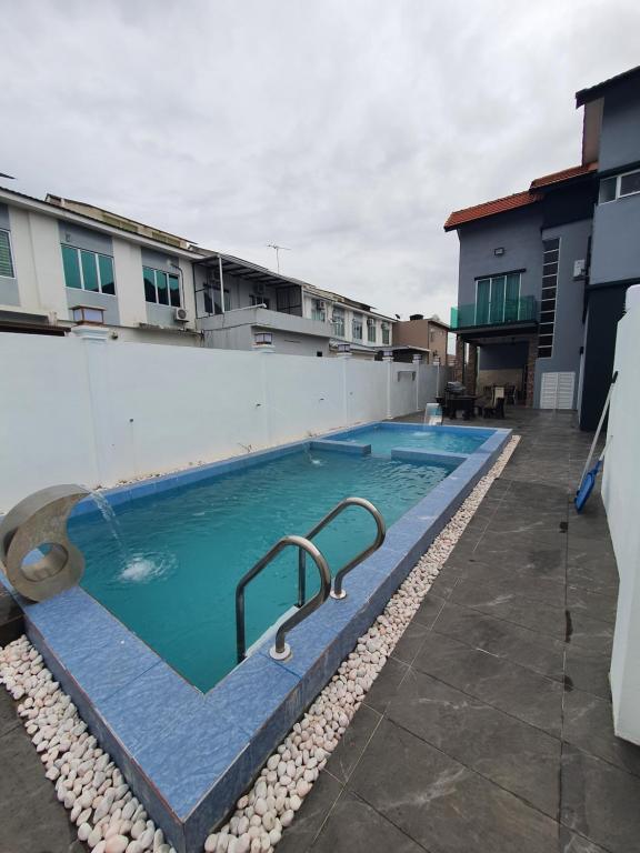 uma piscina ao lado de um edifício em VILLA SARA PRIVATE POOL ALOR SETAR em Langgar
