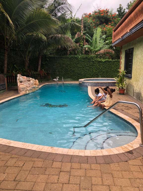 una piscina con dos personas sentadas en el agua en Hidden Oasis in Mandeville en Mandeville