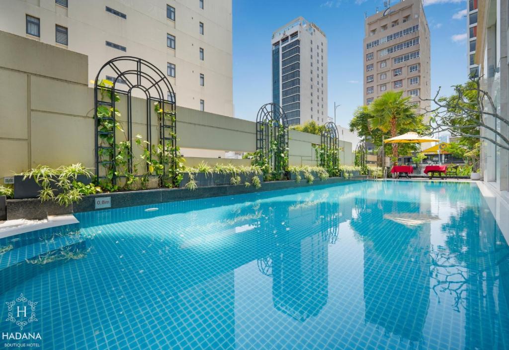 a swimming pool in a building with tall buildings at Hadana Boutique Hotel in Danang