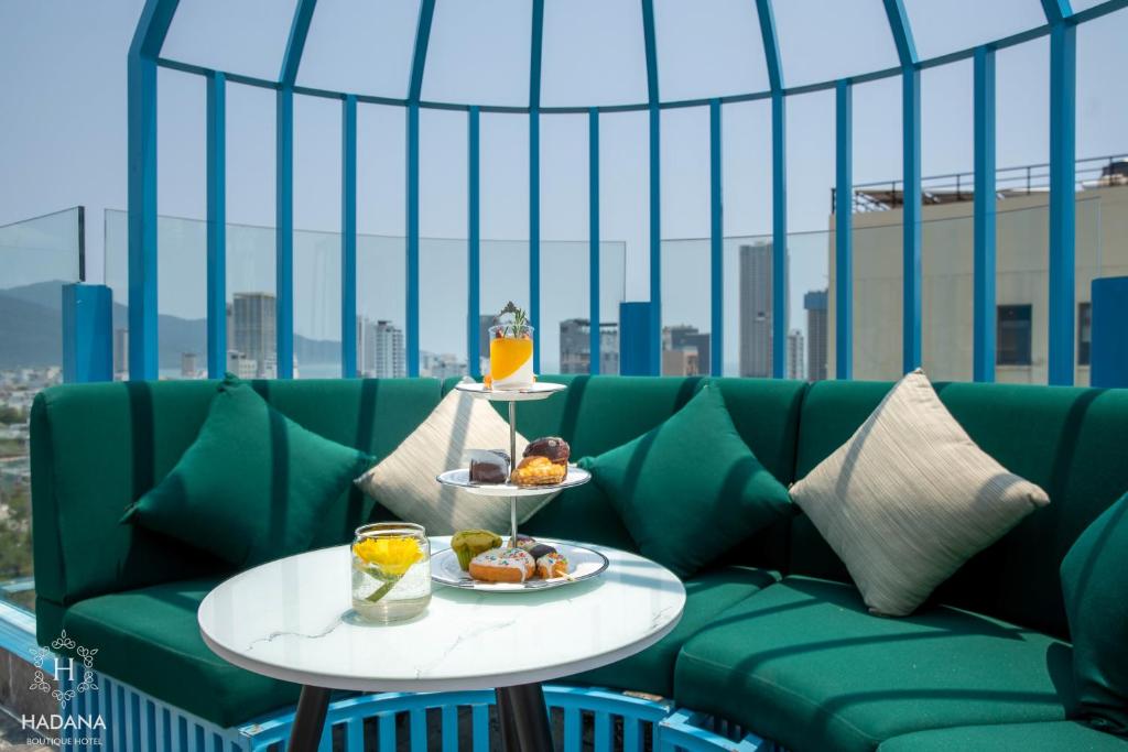 A curved green banquette offers a skyline-facing setting for plated food and drinks.