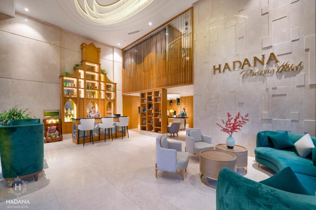 A bright hotel lobby lounge with turquoise seating and a decorative wood display wall.