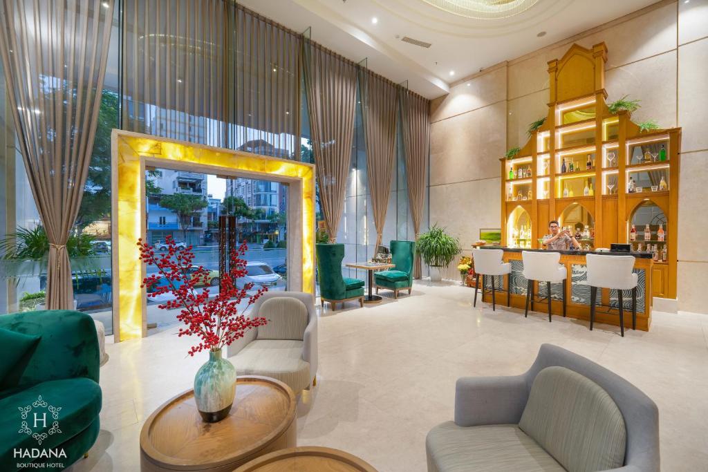 The lobby combines lounge seating with a small illuminated bar beside tall street-facing windows.