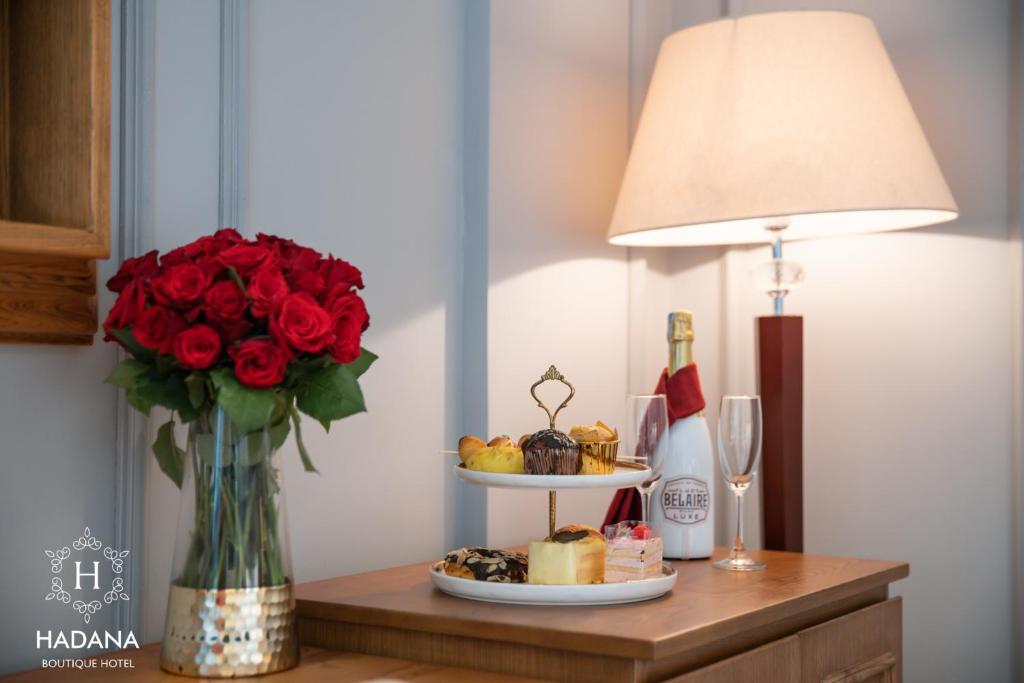 A styled in-room welcome spread with roses, pastries, fruit and a bottle of sparkling wine.