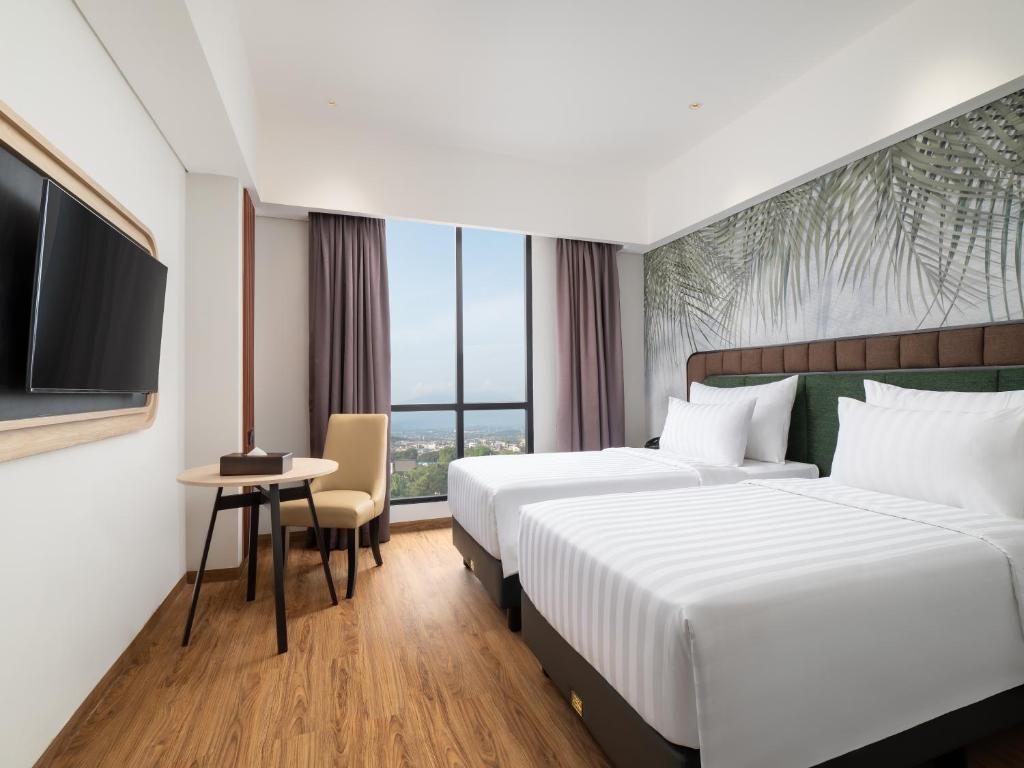 Postel nebo postele na pokoji v ubytování Luminor Hotel Padjadjaran Bogor by WH