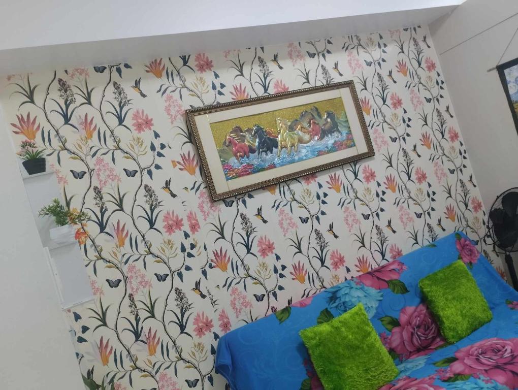 um quarto com uma pintura na parede com flores em Staycation at moa em Manila