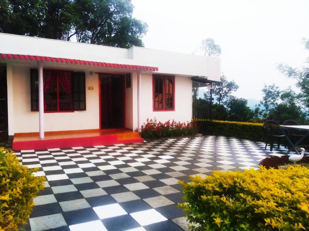 a white house with a black and white checkered floor at Blackcherry Munnar in Munnar