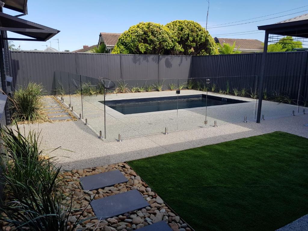a backyard with a swimming pool and a grass yard at Perfect Large Multi Family Accommodation in Yarrawonga
