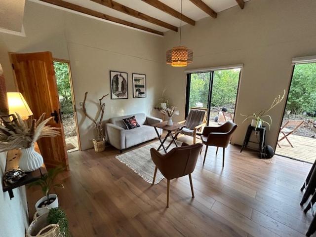 een woonkamer met een bank en een tafel en stoelen bij Casa Maqui in Talca