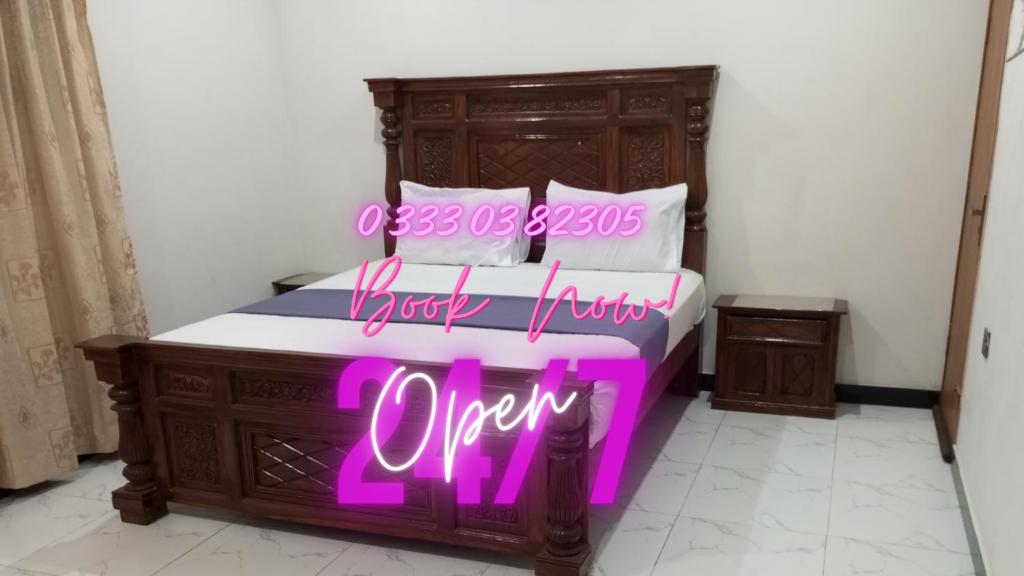 a bed with a neon sign that says open at Nursery Inn in Karachi