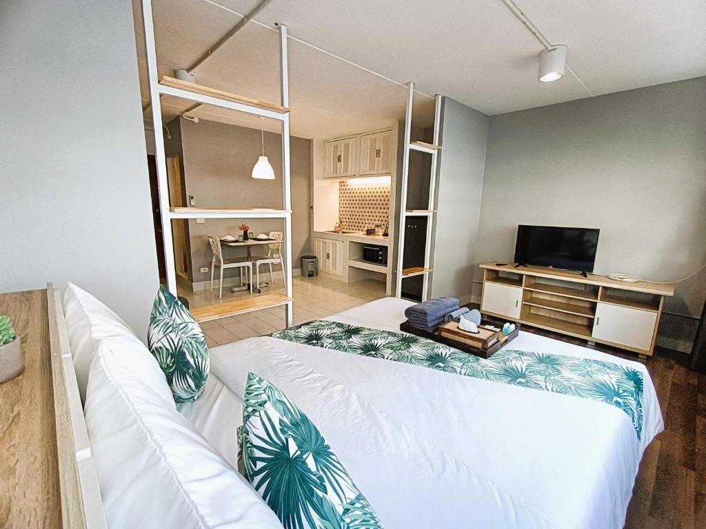 1 dormitorio con 1 cama grande y TV en DHIresidence at Impact,Muangthongthani en Pak Kret