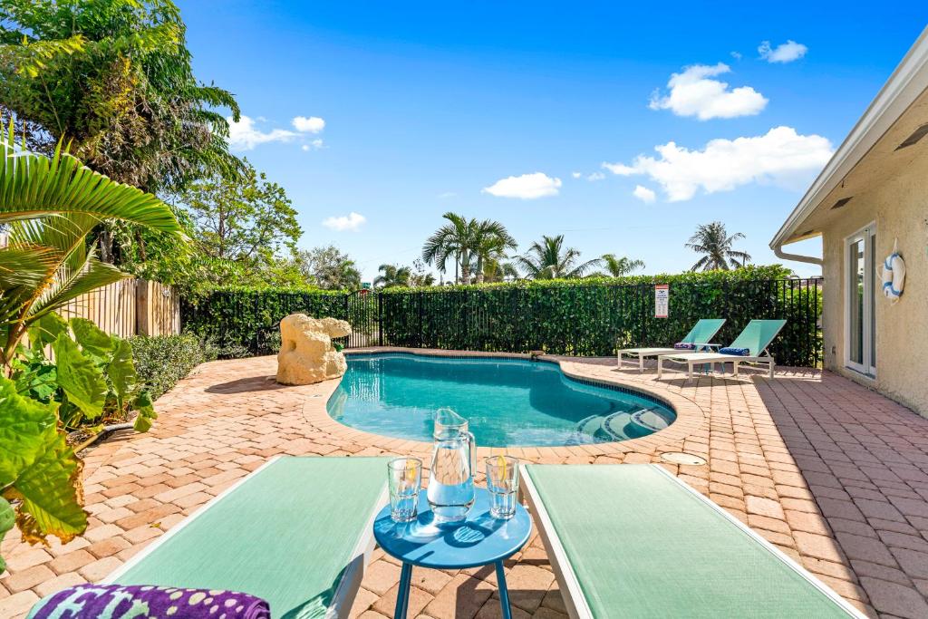 uma piscina com duas mesas e cadeiras num quintal em Nadios casa em Deerfield Beach