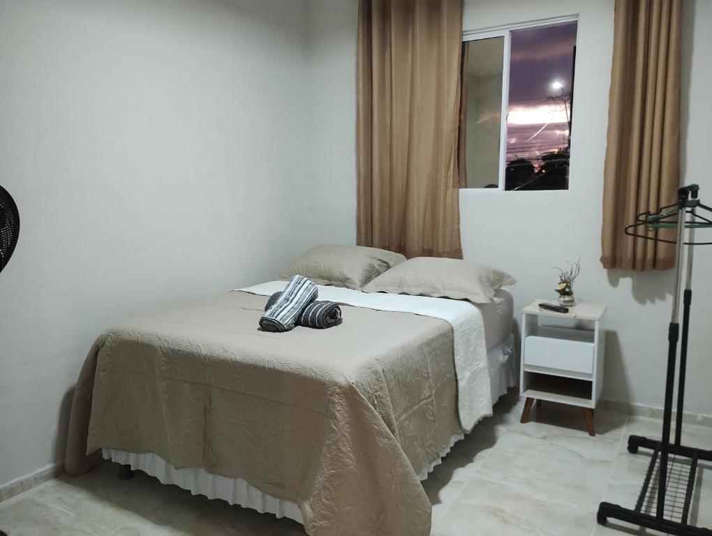 a bedroom with a bed with a table and a window at New House Temporada in João Pessoa