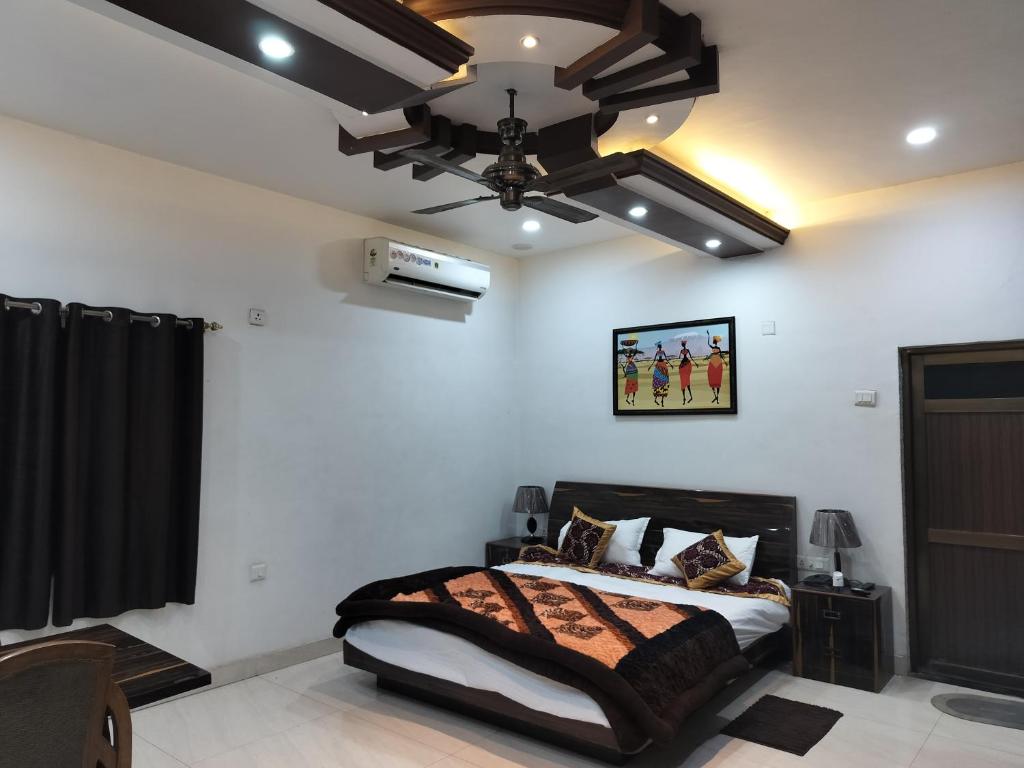 Pura RaghunāthHotel Dawat的带床和吊扇的卧室