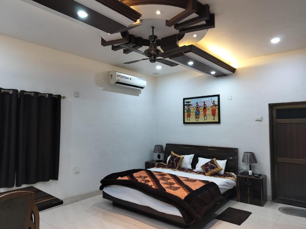 a bedroom with a bed and a ceiling fan at Hotel Dawat in Pura Raghunāth