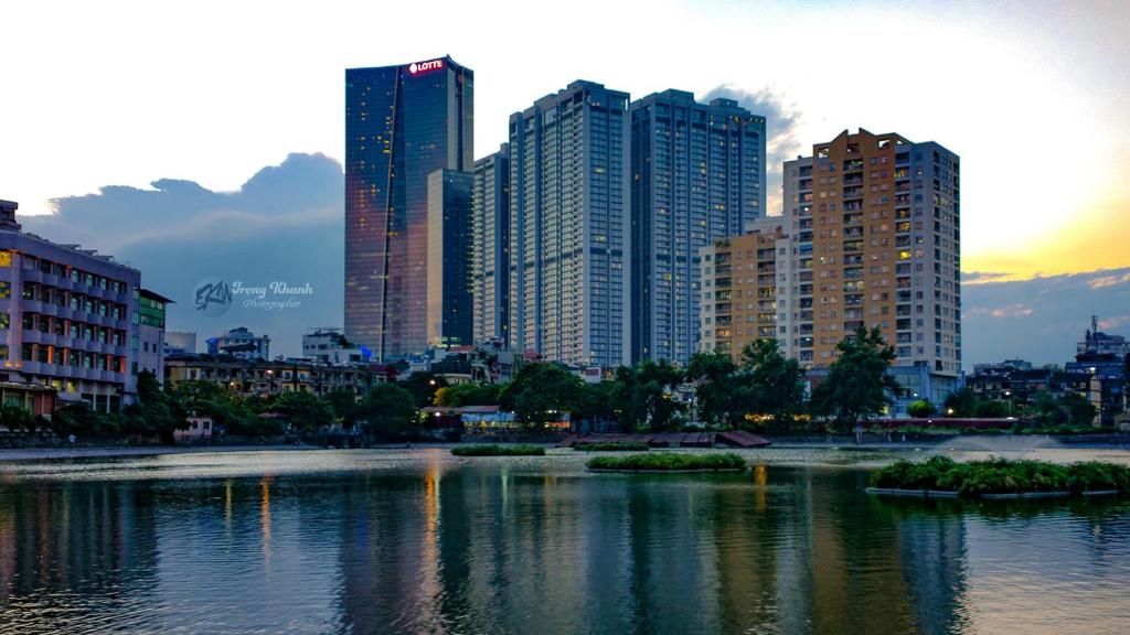 un perfil urbano con edificios altos y un cuerpo de agua en Lami Homestay and Apartments, en Hanói